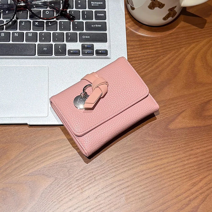 Celia pebbled vegan leather trifold wallet with knotted strap and silver-tone charm