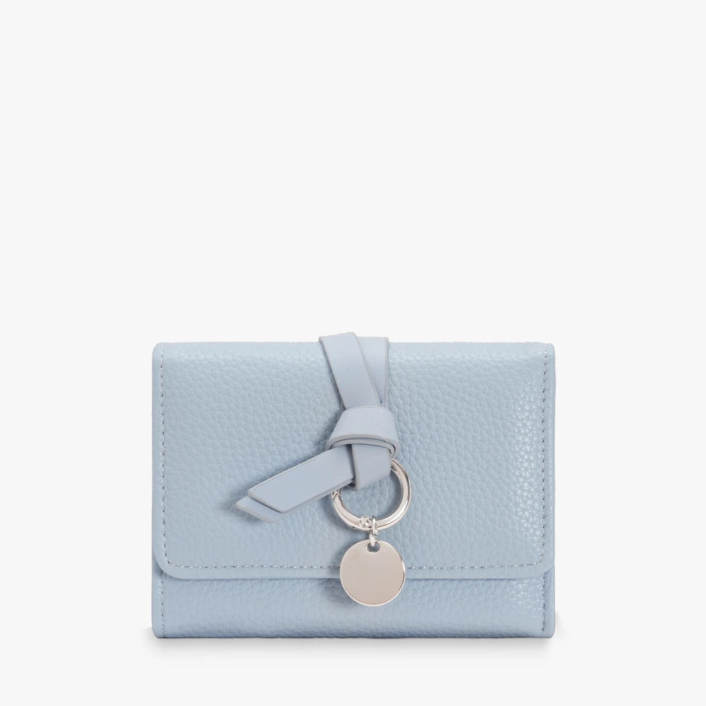 Celia pebbled vegan leather trifold wallet with knotted strap and silver-tone charm in Light Blue