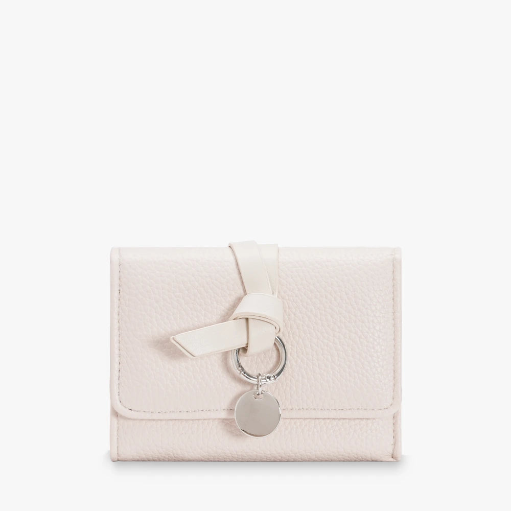 Celia pebbled vegan leather trifold wallet with knotted strap and silver-tone charm in Cream