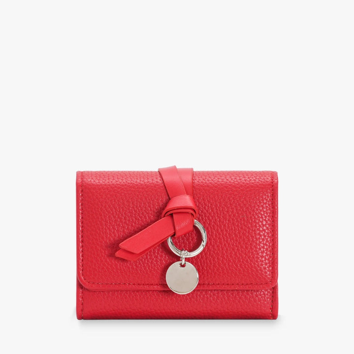 Celia pebbled vegan leather trifold wallet with knotted strap and silver-tone charm in Red