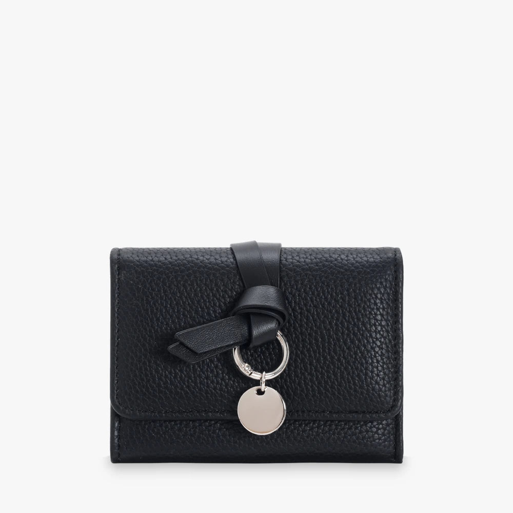Celia pebbled vegan leather trifold wallet with knotted strap and silver-tone charm in Black
